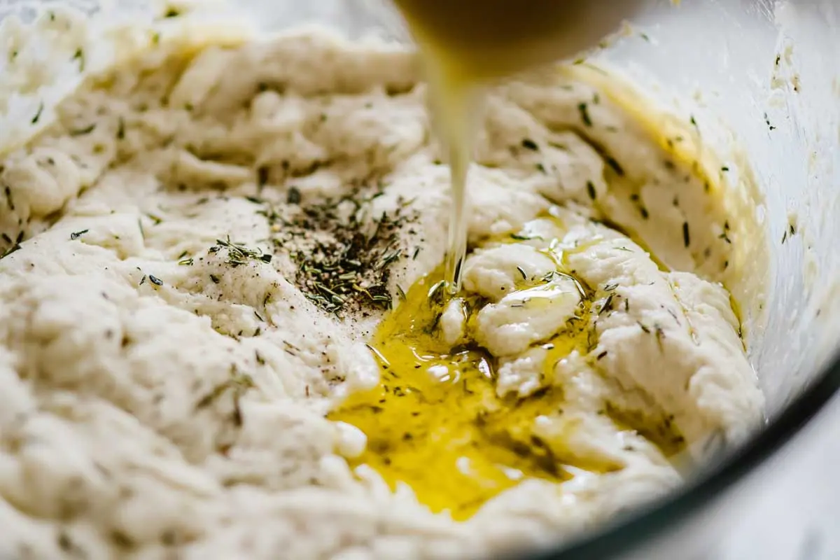 A bowl of gluten-free sourdough discard dough, mixing ingredients for crackers.