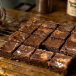 Freshly baked sourdough discard brownies cooling on a wire rack, showing a glossy, fudgy texture.