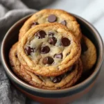 A batch of freshly baked sourdough chocolate chip cookies with golden edges and gooey centers